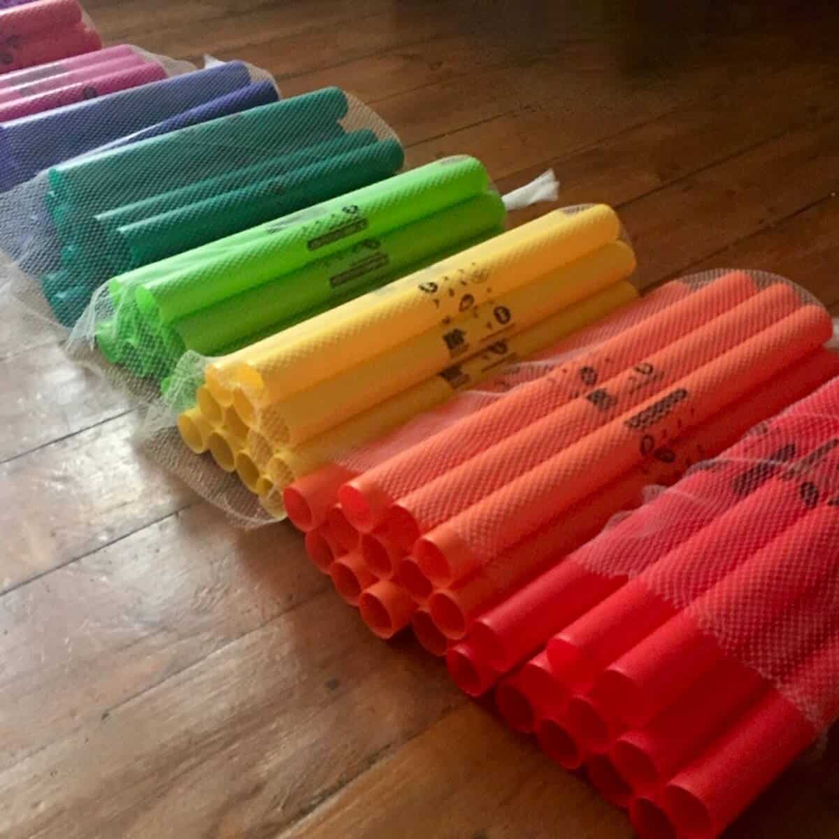 Boomwhacker Instruments Colourful boomwhacker rhythm instruments stacked in rows ready for a drumming workshop.