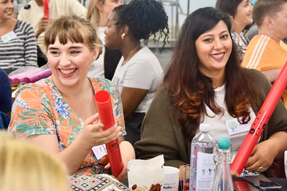 Women playing boomwhackers at a charity celebration.